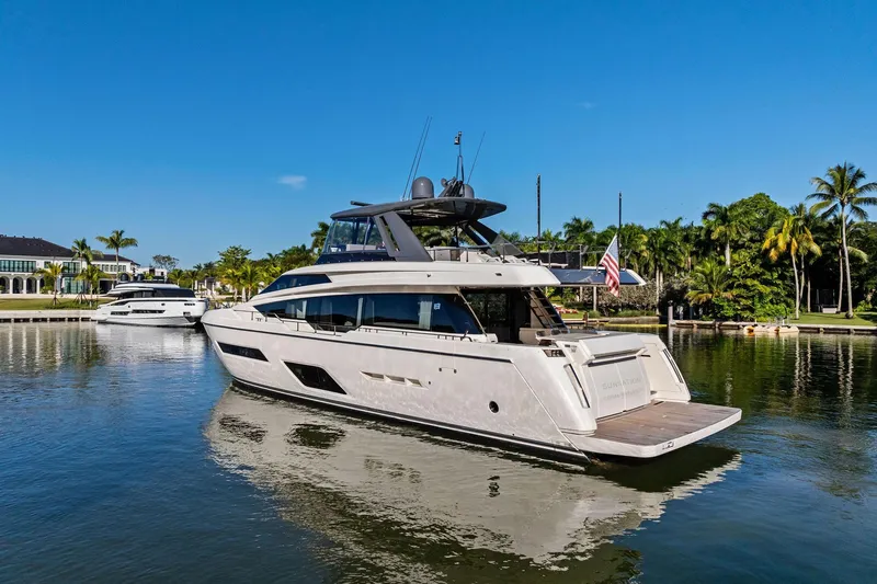 Slide: The Image of 2019 Ferretti Yachts 780 on serene water, surrounded by lush greenery and clear blue sky. - 6