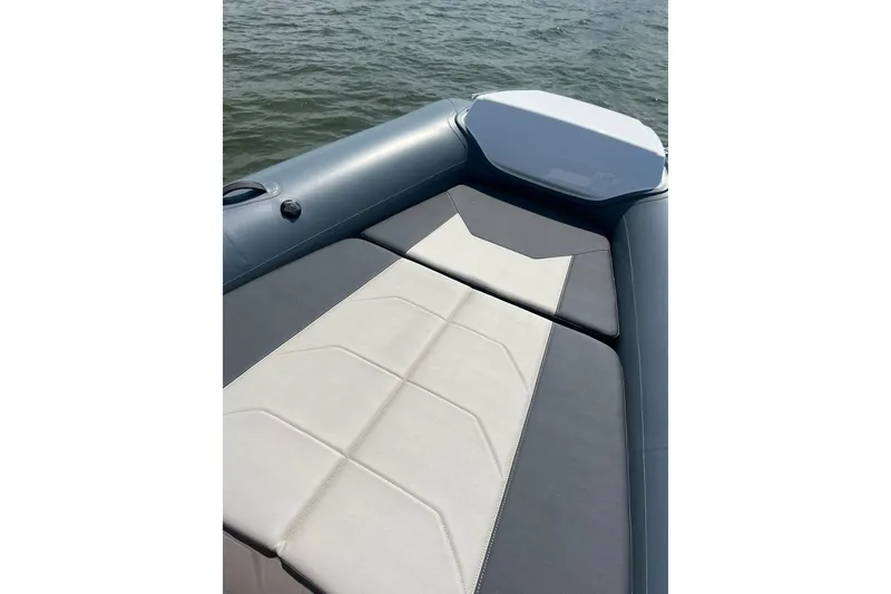 Slide: The Image of 2025 Grand Inflatables G850 boat with sleek seating on calm water. - 15