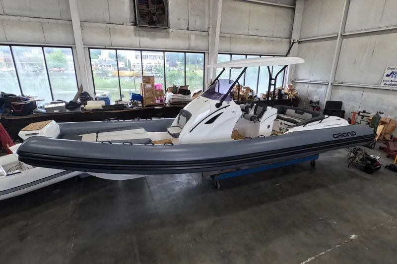 Slide: The Image of 2025 Grand Inflatables G850 boat in a warehouse setting, showcasing sleek design and modern features. - 4