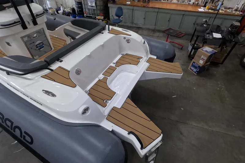 Slide: The Image of 2025 Grand Inflatables G850 boat with sleek deck design in a workshop setting. - 5