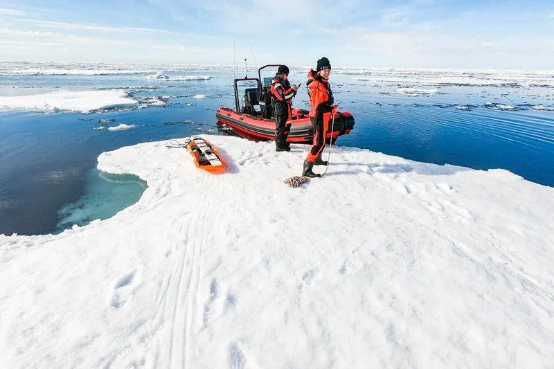 Slide: The Image of Two people on ice beside Highfield Patrol 500 boat, 2026 model. - 2