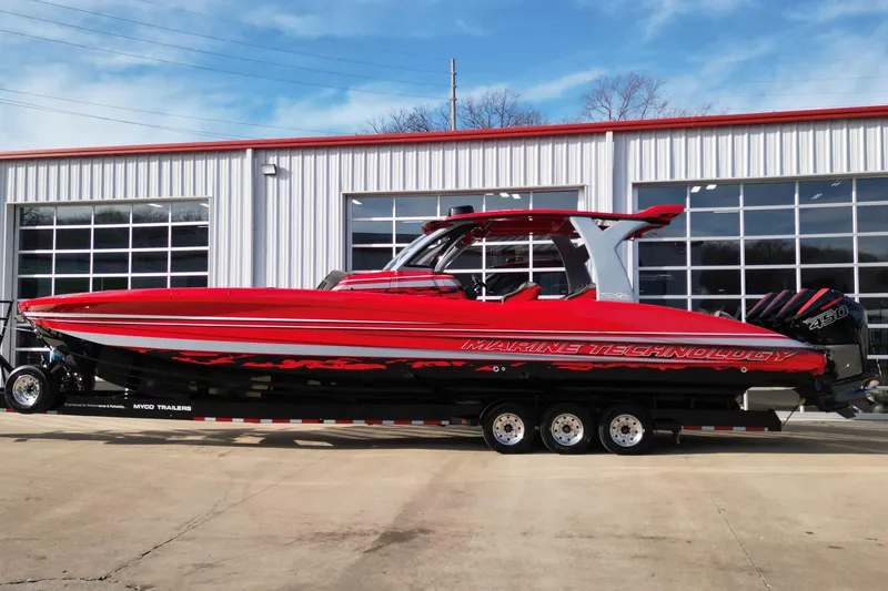 The Image of Red 2020 MTI 42V powerboat on trailer, parked outside a garage. - 0