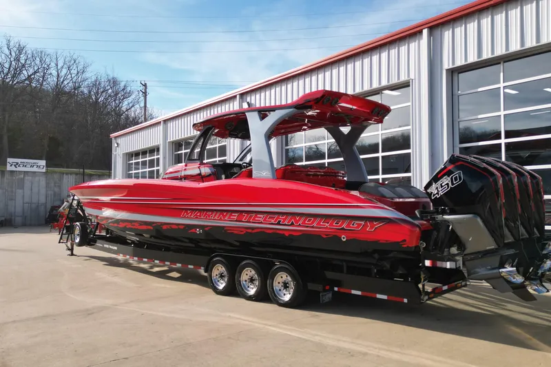 Slide: The Image of Red 2020 MTI 42V powerboat with quad engines on a trailer outside a garage. - 16