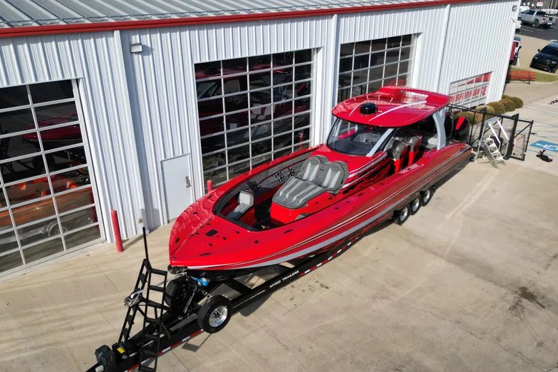 Slide: The Image of Red 2020 MTI 42V powerboat on trailer outside a garage. - 2