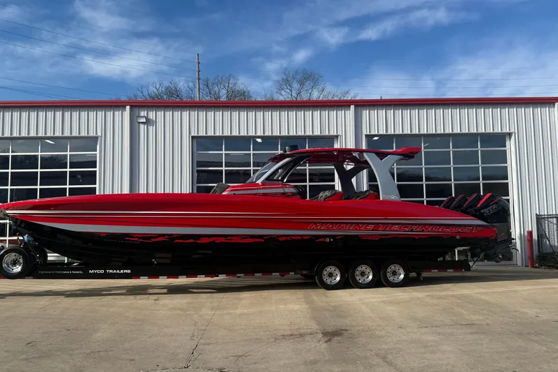 Slide: The Image of Red 2020 MTI 42V boat on trailer, parked outside a garage. - 22