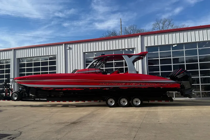 Slide: The Image of Red 2020 MTI 42V powerboat on trailer, parked outside a modern garage. - 23