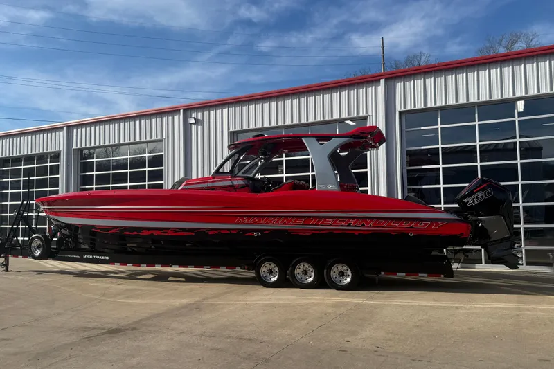 Slide: The Image of Red 2020 MTI 42V boat on trailer outside a modern garage. - 27
