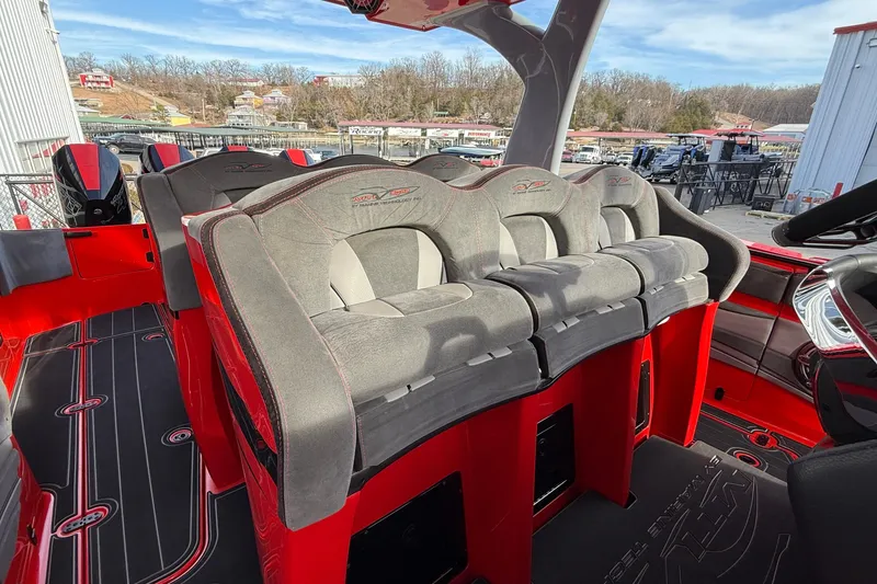 Slide: The Image of 2020 MTI 42V boat interior with red and gray seating, docked outdoors. - 29