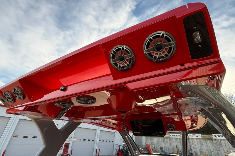 Slide: The Image of Red MTI 42V boat with speakers, 2020 model, under a cloudy sky. - 34