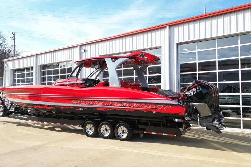 Slide: The Image of Red 2020 MTI 42V powerboat on trailer, parked outside a garage. - 6