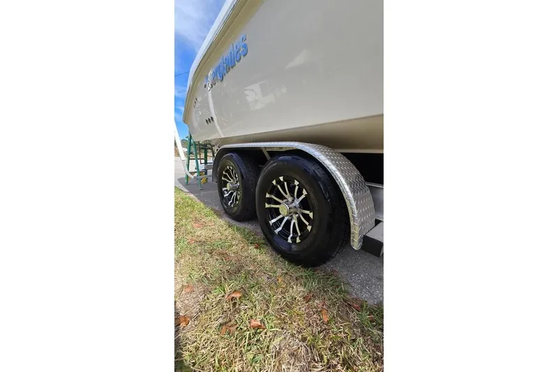 Slide: The Image of 2014 Everglades 295 Pilot boat on trailer with shiny wheels, side view. - 16