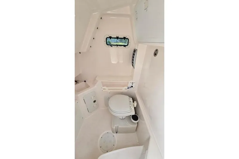 Slide: The Image of Interior of 2014 Everglades 295 Pilot boat, featuring a compact marine toilet. - 30