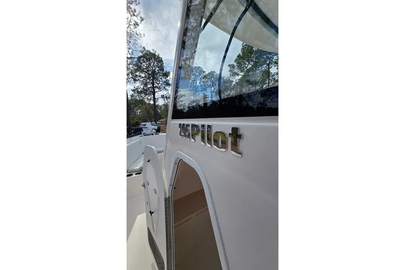 Slide: The Image of 2014 Everglades 295 Pilot boat, side view with logo and trees reflected. - 37
