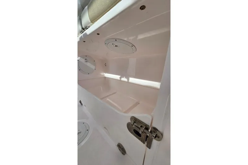 Slide: The Image of Storage compartment inside 2014 Everglades 295 Pilot boat, featuring secure latch and clean interior. - 41