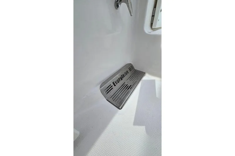 Slide: The Image of Footrest in 2014 Everglades 295 Pilot boat interior, featuring branded metal design. - 44