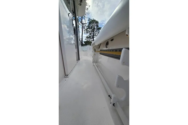 Slide: The Image of Side view of a 2014 Everglades 295 Pilot boat, showcasing sleek design and rod holders. - 45