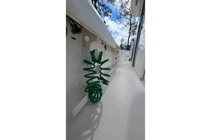 Slide: The Image of 2014 Everglades 295 Pilot boat deck with green coiled hose. - 47