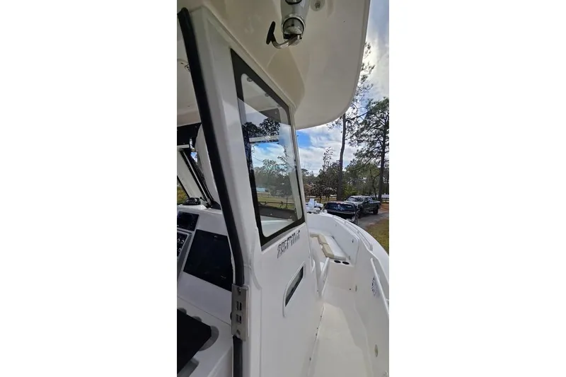 Slide: The Image of 2014 Everglades 295 Pilot boat, side view with open cabin door, parked outdoors. - 49