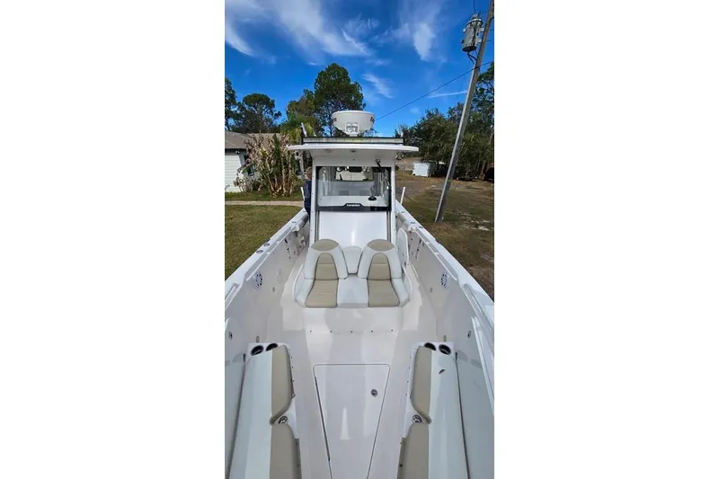 Slide: The Image of 2014 Everglades 295 Pilot boat with seating, outdoors under blue sky. - 53