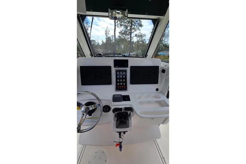 Slide: The Image of 2014 Everglades 295 Pilot boat dashboard with steering wheel and control panel. - 56
