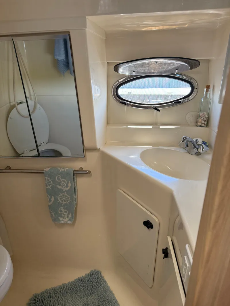 Slide: The Image of 1996 Tiara Yachts 3500 Express bathroom with porthole and sink. - 21