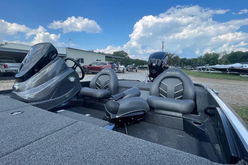 Slide: The Image of 2021 Nitro Z17 boat interior with gray seats and steering console, parked outdoors. - 7