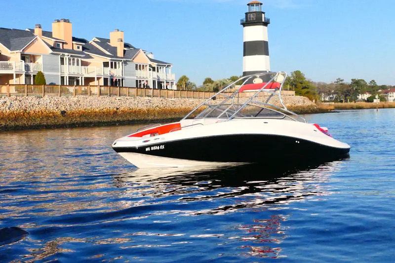 The Image of 2009 Sea-Doo 230 Wake boat near lighthouse and waterfront homes. - 0