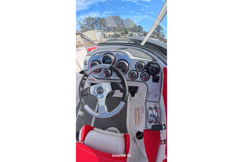 Slide: The Image of 2009 Sea-Doo 230 Wake boat with red and white interior, docked under blue sky. - 15