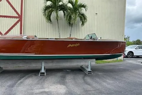 Slide: The Image of 1997 Hacker-Craft 26' Runabout boat displayed outdoors near palm trees. - 23