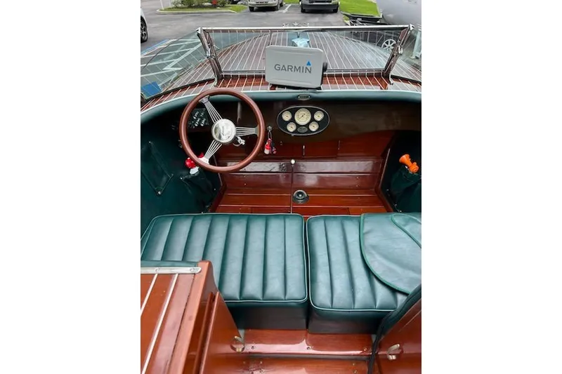 Slide: The Image of 1997 Hacker-Craft 26' Runabout interior with wooden dashboard and Garmin navigation system. - 26