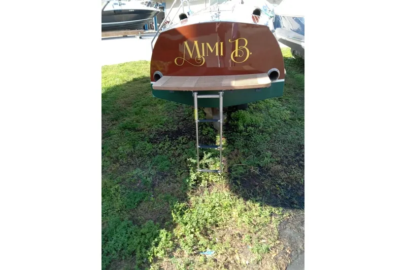 Slide: The Image of 1997 Hacker-Craft 26' Runabout boat named "Mimi B" with rear ladder on grass. - 41