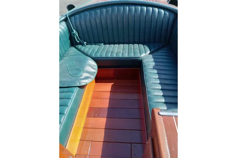 Slide: The Image of Interior of a 1997 Hacker-Craft 26' Runabout with green leather seating and wooden flooring. - 42