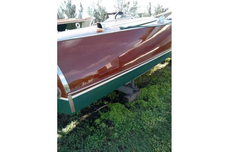 Slide: The Image of 1997 Hacker-Craft 26' Runabout with polished wooden hull on grass. - 45
