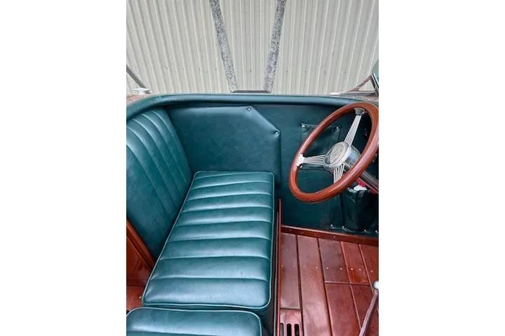 Slide: The Image of Interior of a 1997 Hacker-Craft 26' Runabout with green leather seating and wooden steering wheel. - 9