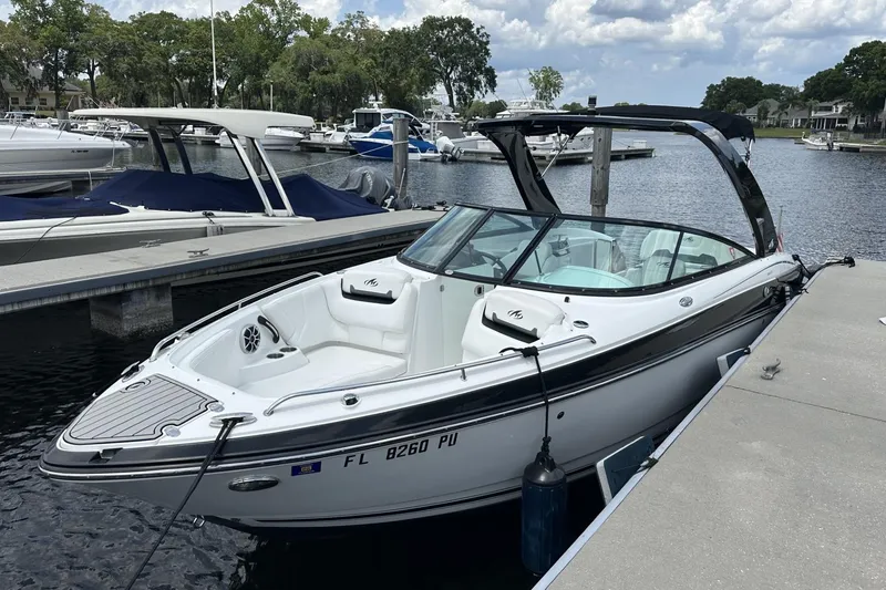Slide: The Image of 2015 Monterey 264FS boat docked at marina, surrounded by other vessels. - 1