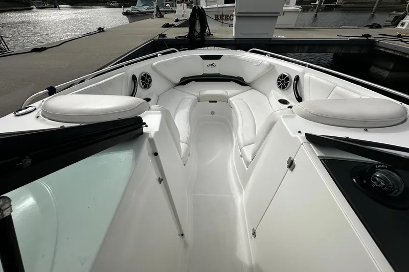 Slide: The Image of 2015 Monterey 264FS boat interior with white seating and speakers at a marina. - 12