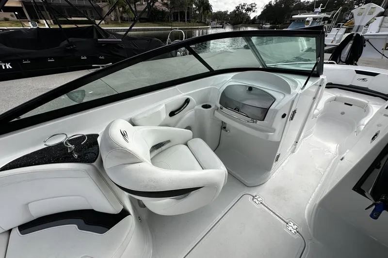Slide: The Image of Interior of a 2015 Monterey 264FS boat, featuring sleek white seating and dashboard. - 23