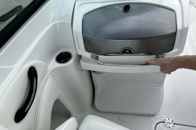Slide: The Image of 2015 Monterey 264FS boat interior with storage compartment and cup holder. - 24