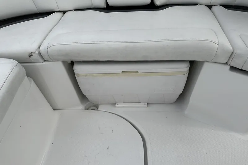 Slide: The Image of 2015 Monterey 264FS boat interior with white cushioned seating and built-in cooler. - 38