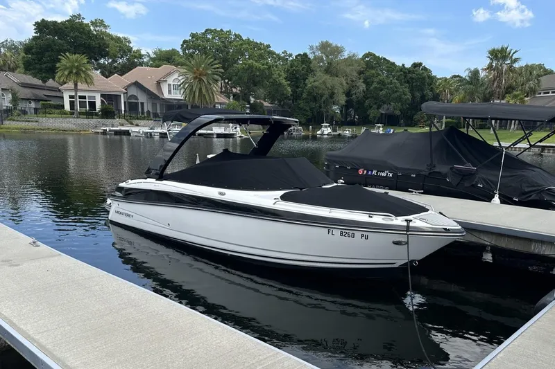 Slide: The Image of 2015 Monterey 264FS boat docked on a serene lake with lush greenery. - 42