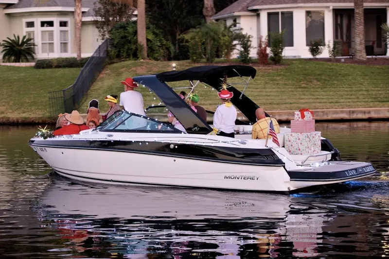 Slide: The Image of 2015 Monterey 264FS boat decorated for a festive celebration on a calm lake. - 43