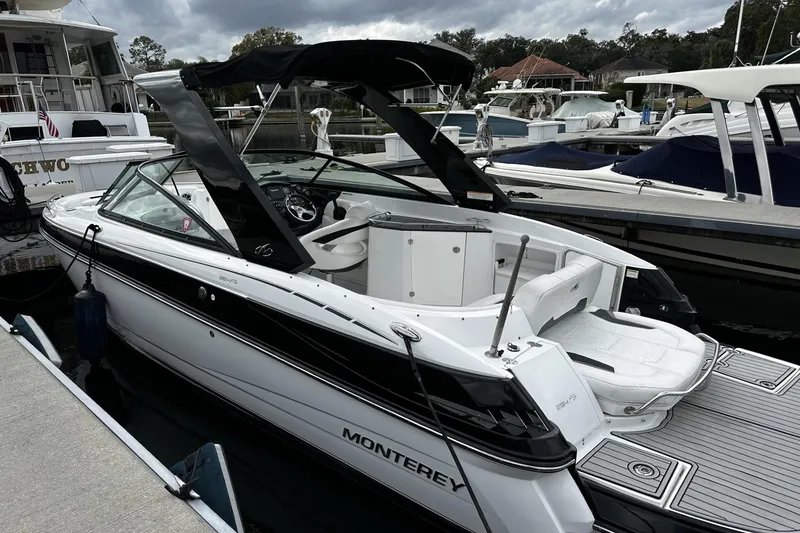 Slide: The Image of 2015 Monterey 264FS boat docked at marina, featuring sleek design and black canopy. - 7