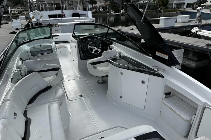 Slide: The Image of 2015 Monterey 264FS boat interior with seating and steering wheel at a marina. - 9