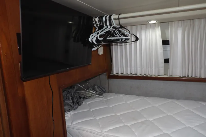 Slide: The Image of Interior of 1992 Carver 28 Aft Cabin Motor Yacht with bed, TV, and hangers. - 26