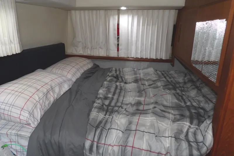 Slide: The Image of Cozy bedroom in 1992 Carver 28 Aft Cabin Motor Yacht with plaid bedding. - 24