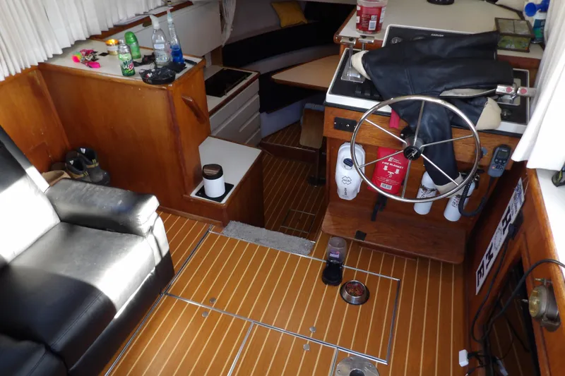 Slide: The Image of Interior of 1992 Carver 28 Aft Cabin Motor Yacht with wooden flooring and steering wheel. - 15