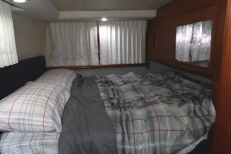 Slide: The Image of Cozy bedroom in 1992 Carver 28 Aft Cabin Motor Yacht with plaid bedding and curtains. - 23