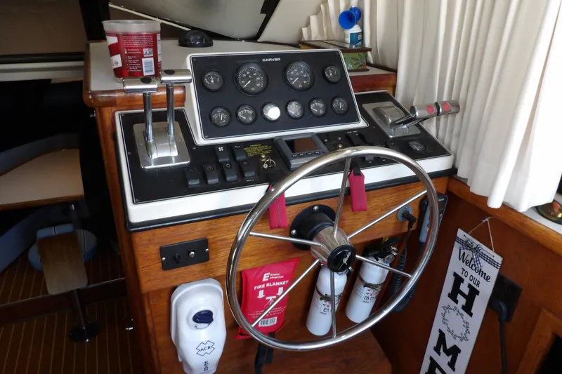 Slide: The Image of 1992 Carver 28 Aft Cabin Motor Yacht helm with steering wheel and control panel. - 16