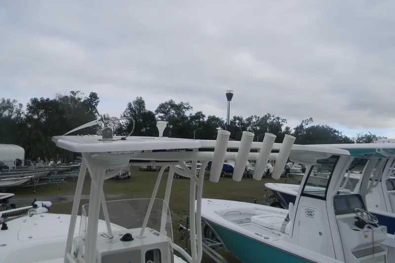 Slide: The Image of 2020 Contender 25 Bay boat with rod holders and navigation equipment, parked outdoors. - 9