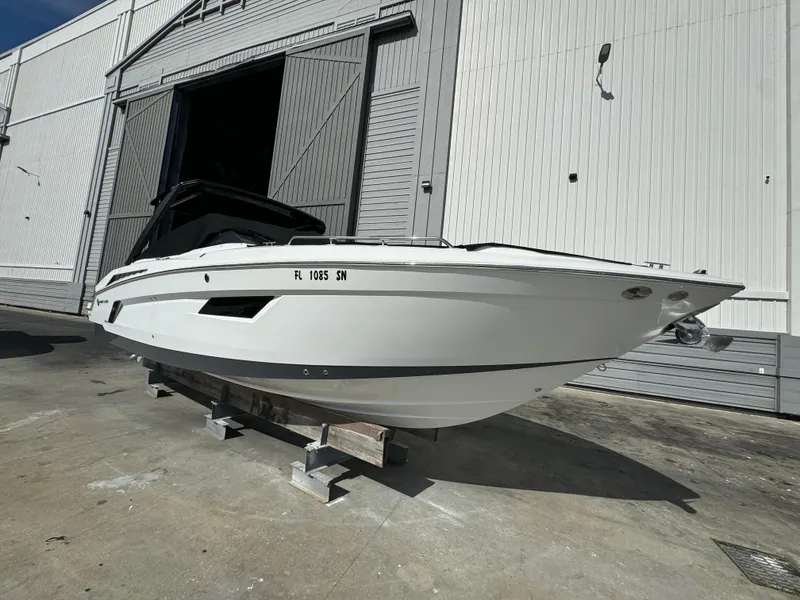 Slide: The Image of 2019 Cruisers Yachts 338 Outboard, white hull, docked outside a large warehouse. - 3